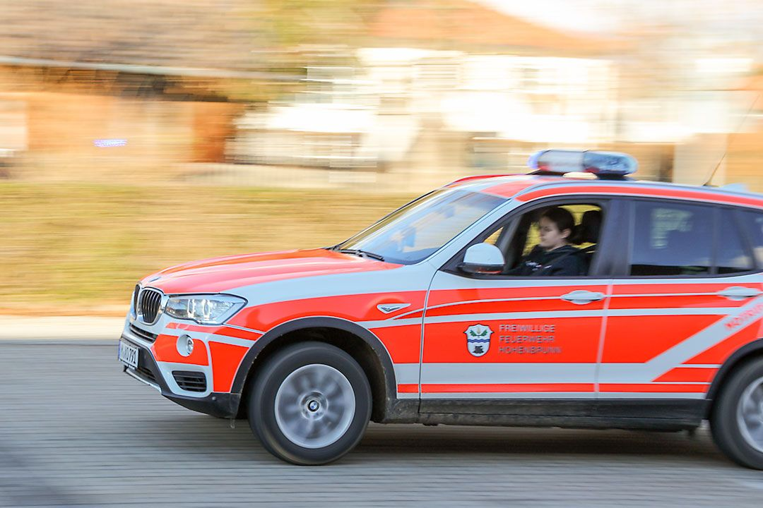 Einsatzfahrzeug der Freiwilligen Feuerwehr Hohenbrunn in Fahrt – Mitzieher mit Bewegungsunschärfe im Hintergrund.