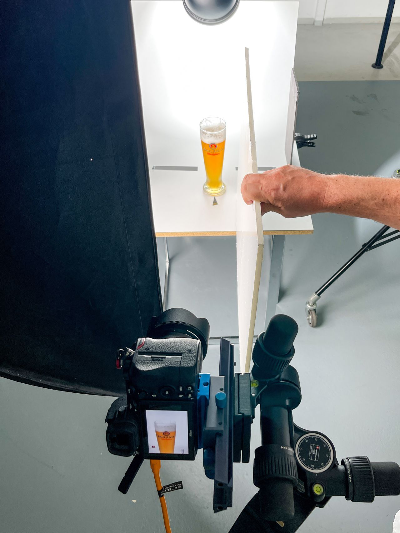 Weißbierglas im Studio-Aufbau mit Dauerlicht, Diffusor und Kamera auf Stativ während der Produktfotografie-Schulung.