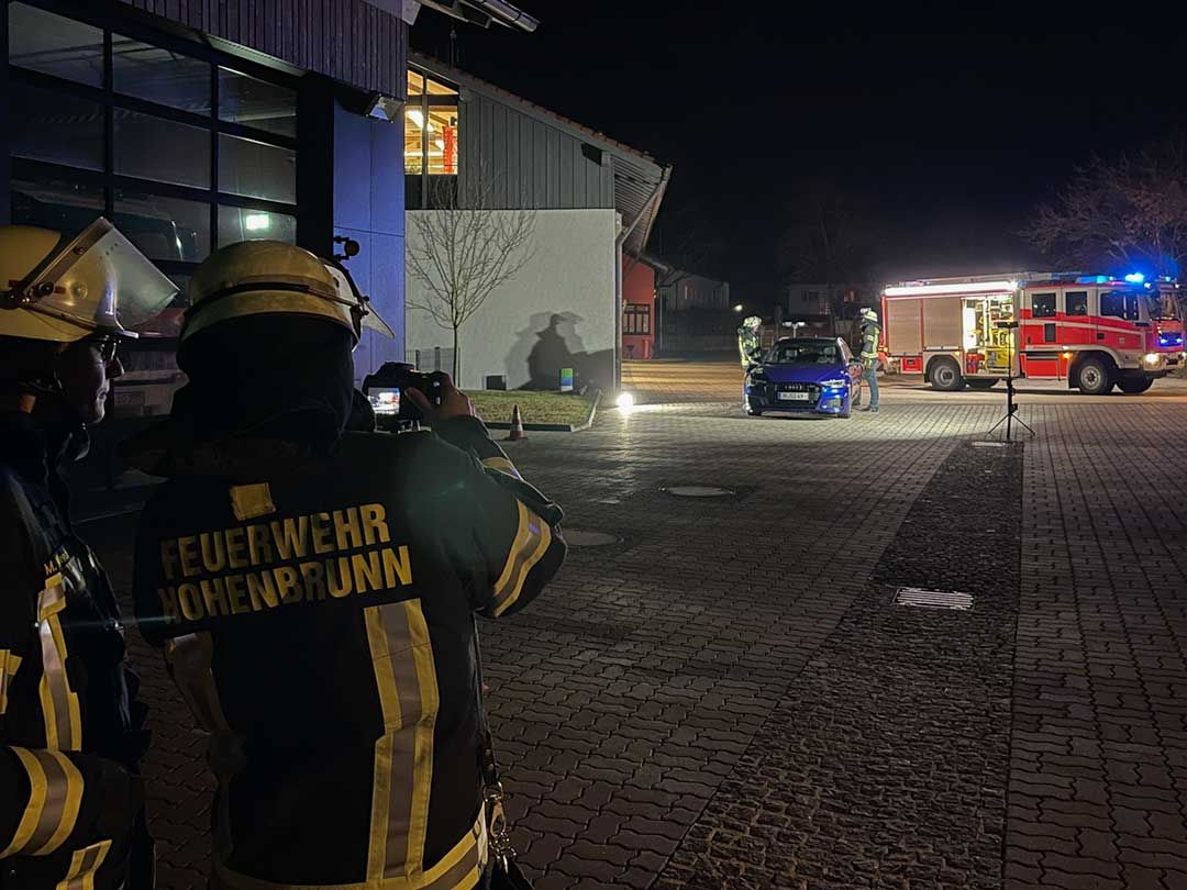 Nachtübung der Freiwilligen Feuerwehr Hohenbrunn – Kameradinnen fotografieren eine Einsatzszene vor dem Gerätehaus.